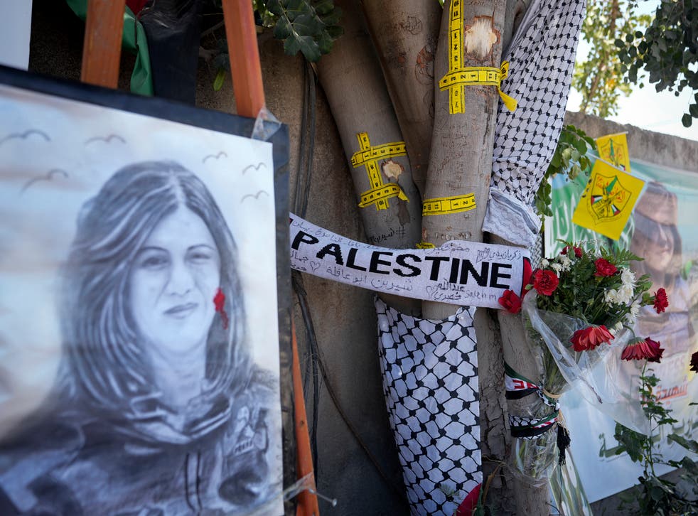 <p>Yellow tape marks bullet holes on a tree and a portrait and flowers create a makeshift memorial on o May 19, 2022, at the site where Palestinian-American Al-Jazeera journalist Shireen Abu Akleh was shot and killed in the West Bank city of Jenin. The Palestinian Authority on Saturday, July 2, 2022, said it has given the bullet that killed Al Jazeera journalist Shireen Abu Akleh to American forensic experts, taking a step toward resolving a standoff with Israel over the investigation into her death. (AP Photo/Majdi Mohammed)</p>