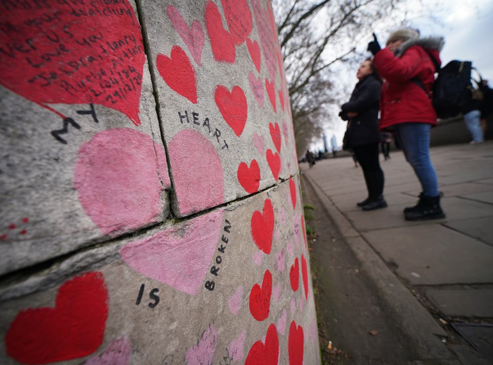 People look at tributes on the Covid memorial wall in central London (Yui Mok/PA)