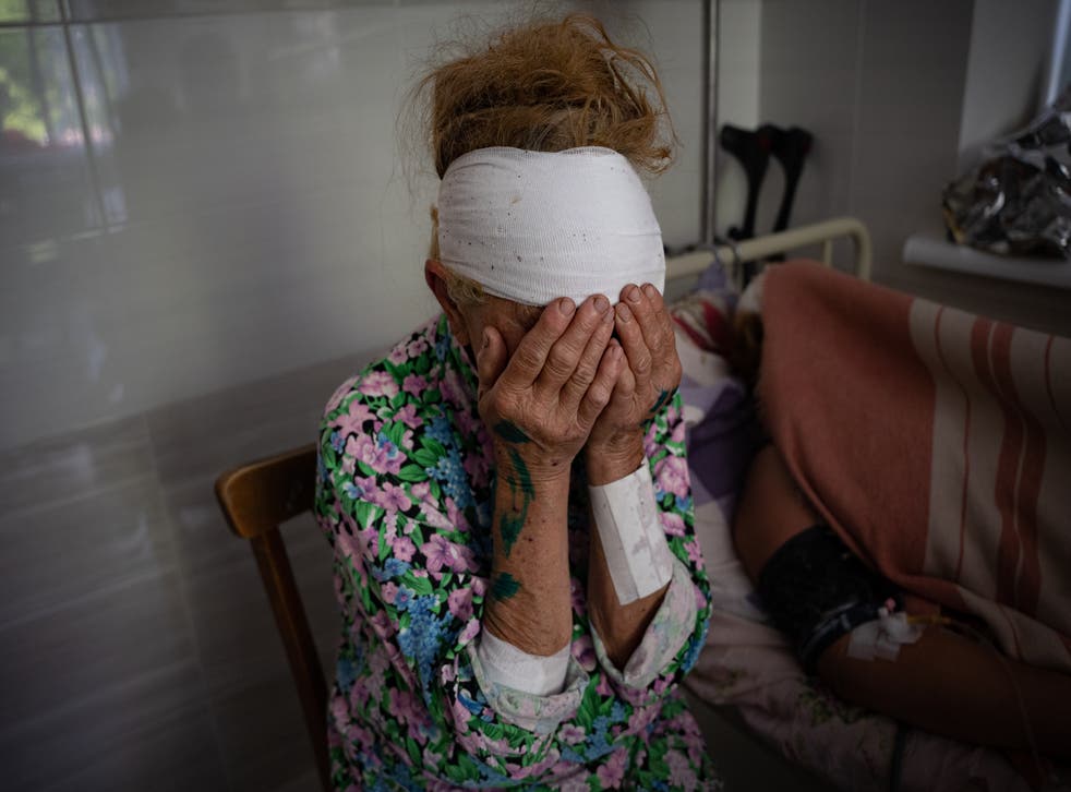 <p>Olga, who was wounded by shelling on Monday, sits next to her neighbour who was badly injured and lost her daughter the day before in a missile strike</p>