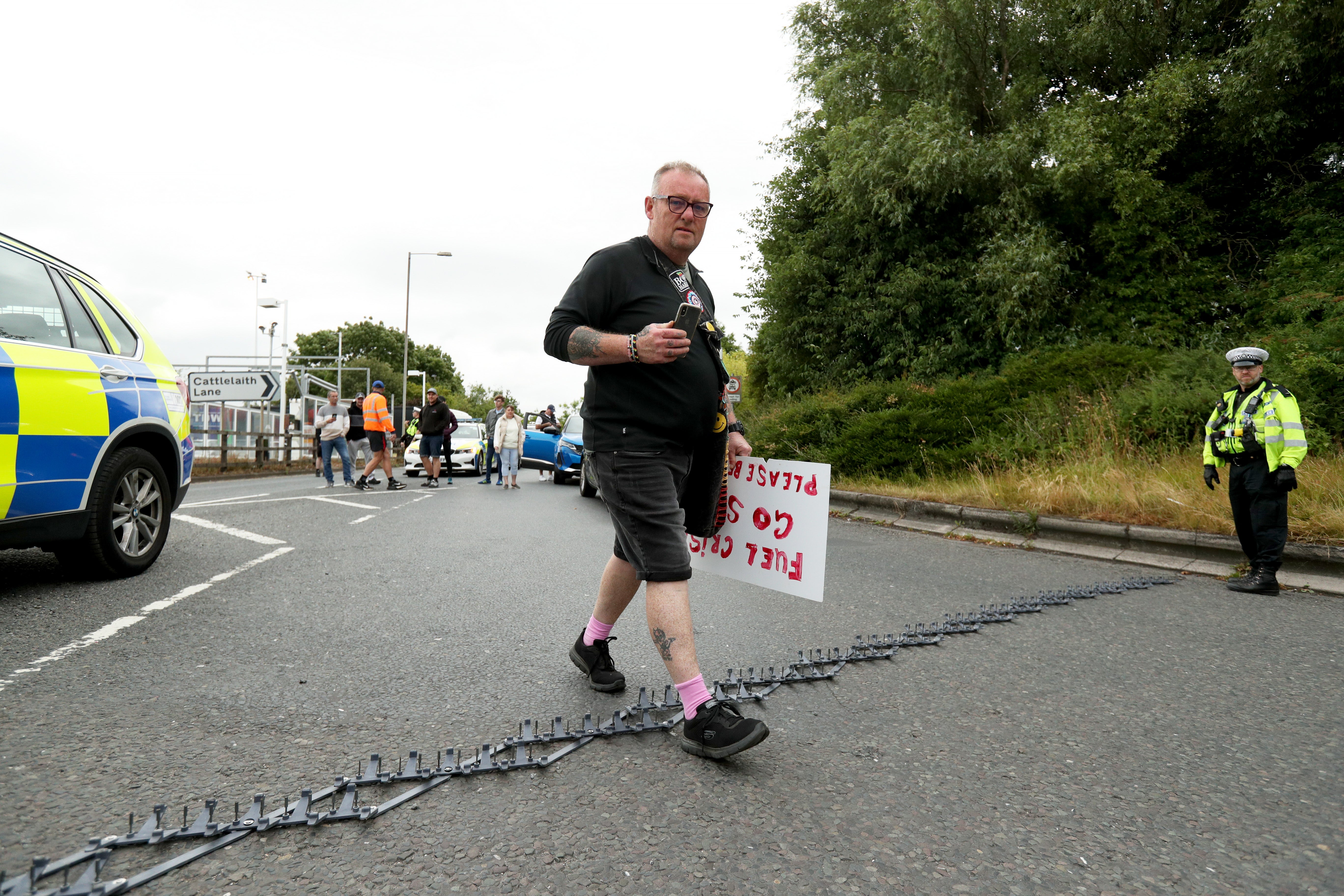 A protester walks over a police stinger as motorways are brought to a standstill