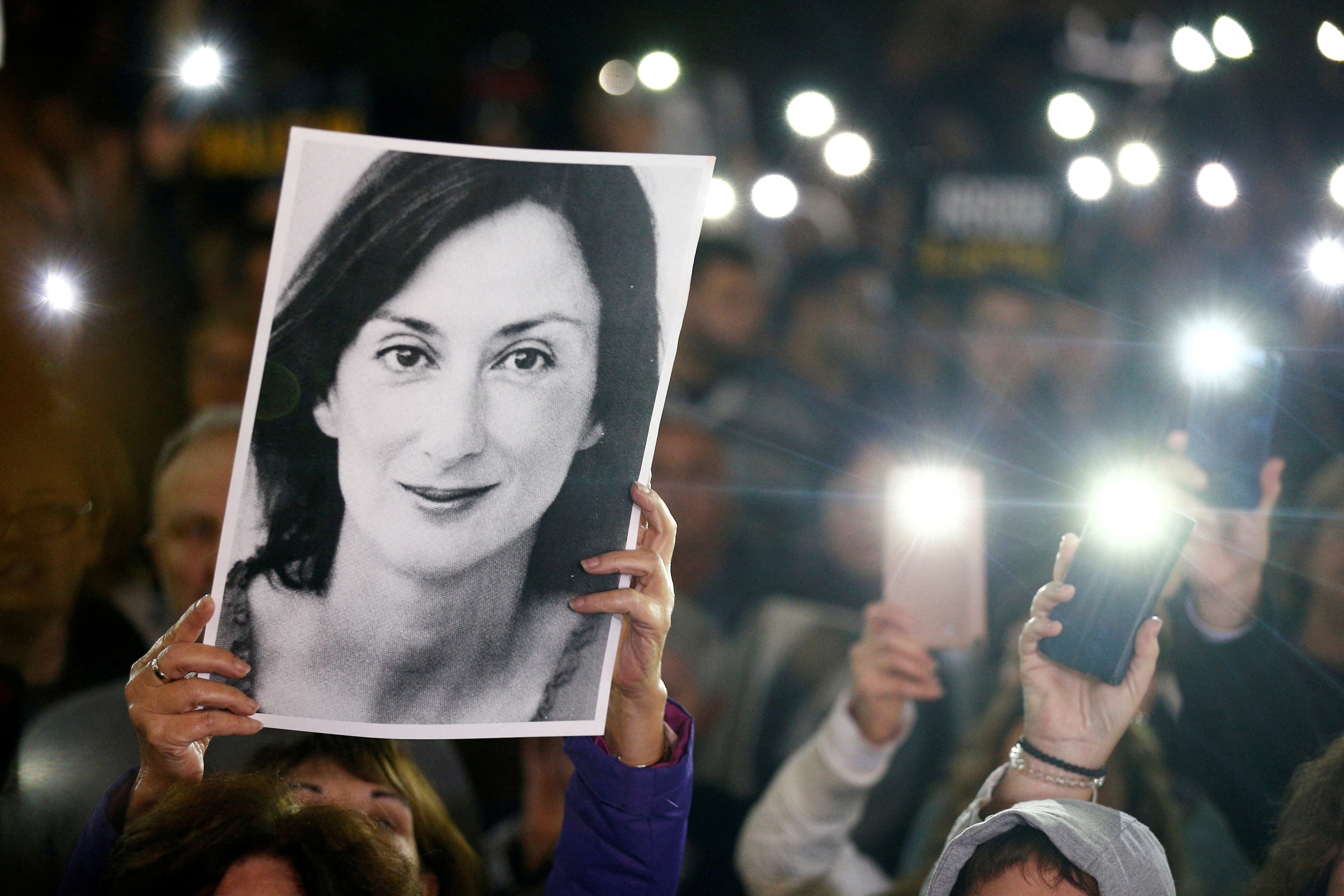 People gather and hold pictures of the journalist Daphne Caruana Galizia