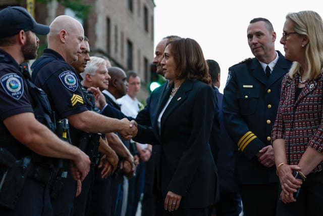 <p>US vice president Kamala Harris, accompanied by her husband Doug Emhoff and Highland Park mayor Nancy Rotering (right), talks with police officers during a visit to the site of a shooting</p>
