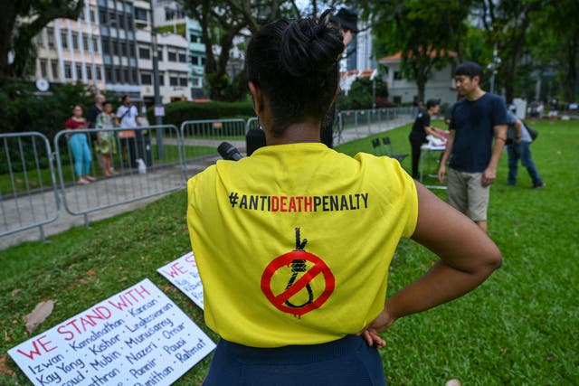 <p>File photo: An activist looks at placards showing the names of individuals currently on death row in Singapore</p>