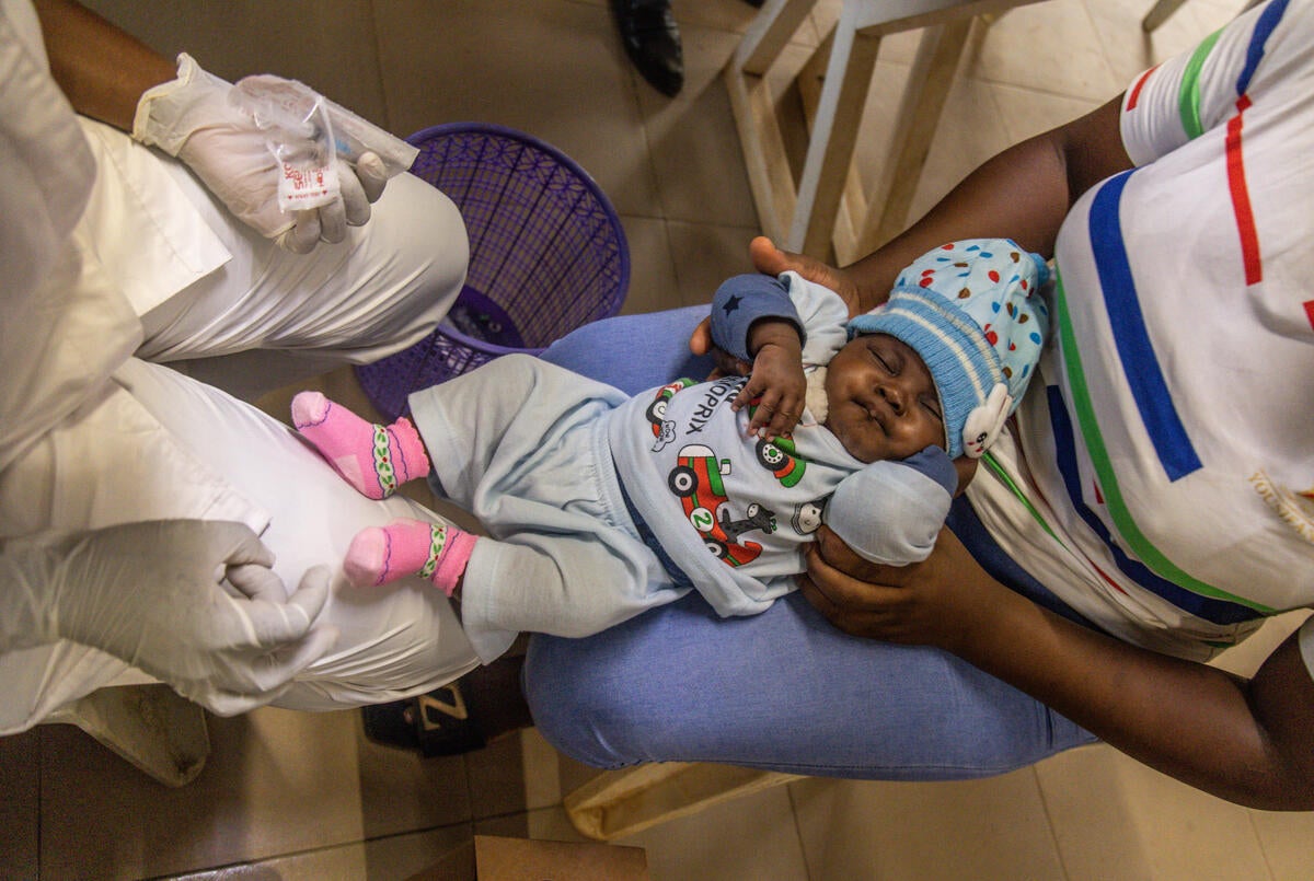 Olatunji administers a vaccine to a child