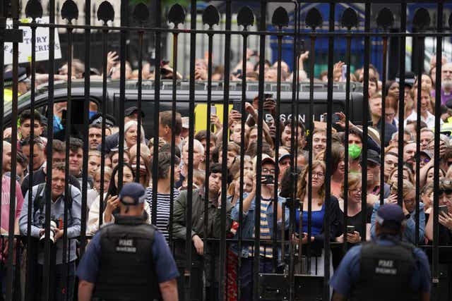 Members of the public stand outside the gates of Downing Street