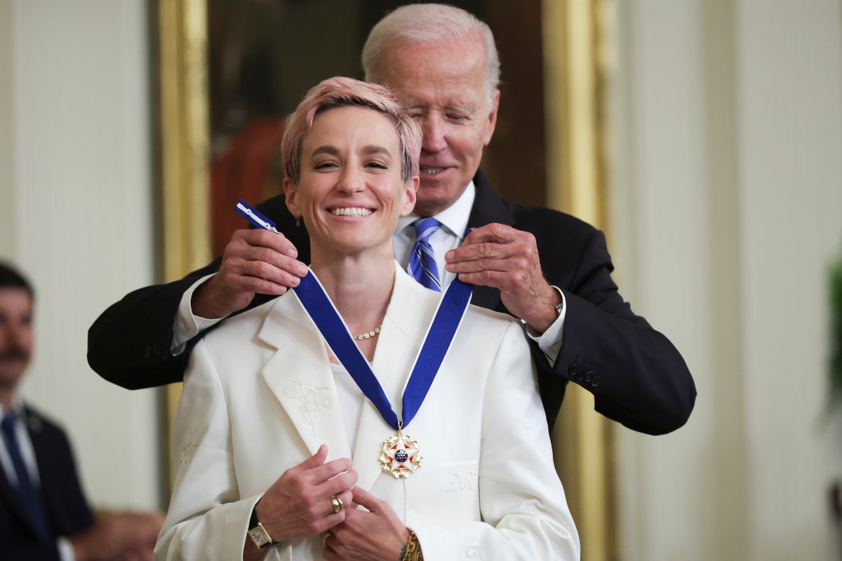 Megan Rapinoe, Başkanlık Özgürlük Madalyası töreninde fotoğraflarını çeken nişanlısı Sue Bird'e gülümsüyor