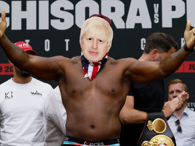<p>Derek Chisora weighs in while wearing a Boris Johnson mask</p>