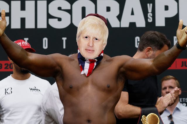 <p>Derek Chisora weighs in while wearing a Boris Johnson mask</p>