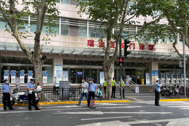 <p>Police officers stand outside Ruijin Hospital following the incident </p>