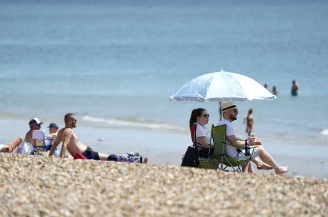 People enjoy the warm weather on Southsea Beach in Hampshire (Andrew Matthews/PA)