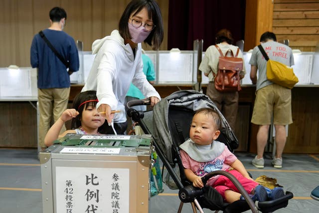 <p>A woman casts ballot  during the Upper House election at a polling station in Tokyo, Japan </p>