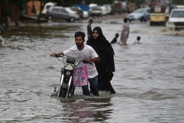 <p>A man pushes his motorbike along a flooded street after a monsoon rainfall in Karachi </p>