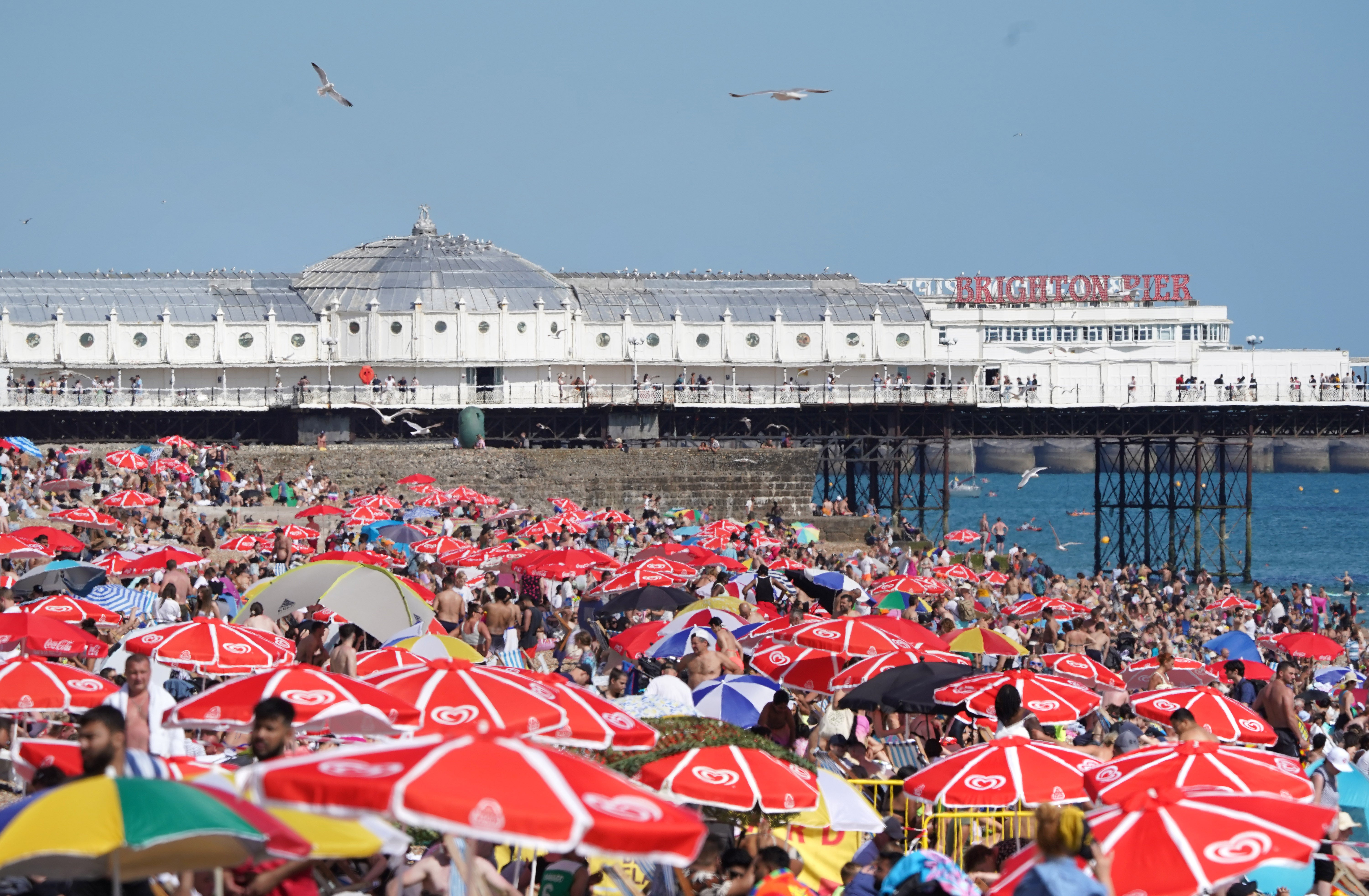 People enjoy the warm weather at Brighton beach in West Sussex (Gareth Fuller/PA)