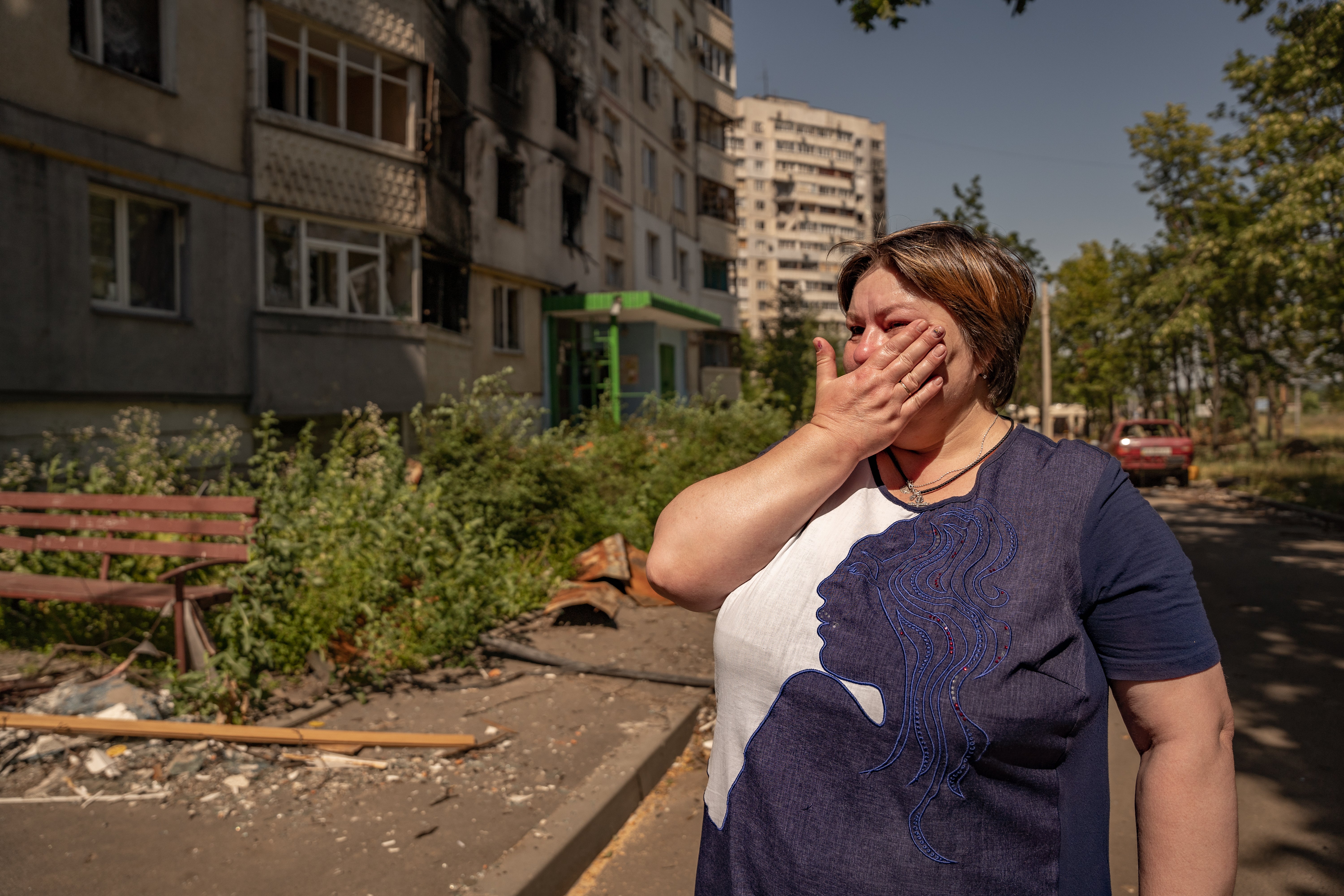 Svitlana in tears next to her bombed-out flat in Saltivka