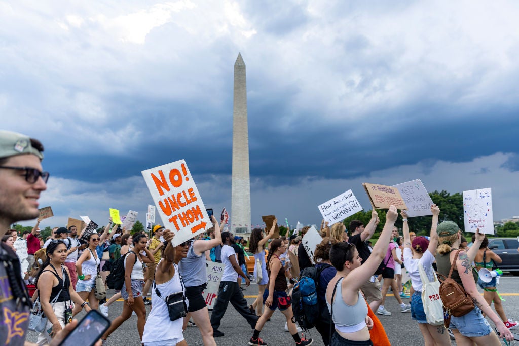 Protesters march past the Washington monument at the 2022 Women’s March in Washington DC