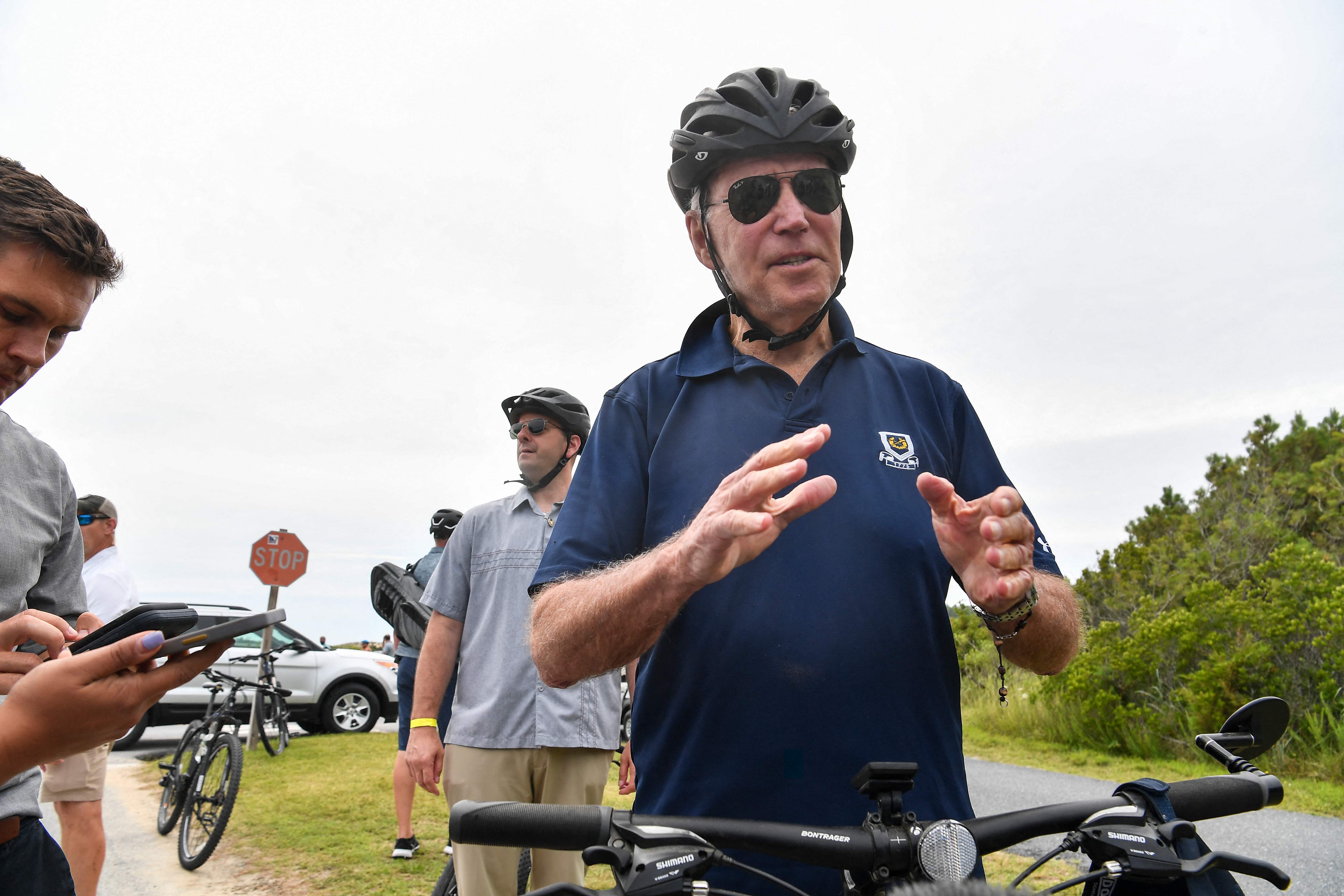 President Joe Biden stops to talk to reporters during a bike ride in Rehobeth Beach, Delaware, on 10 July