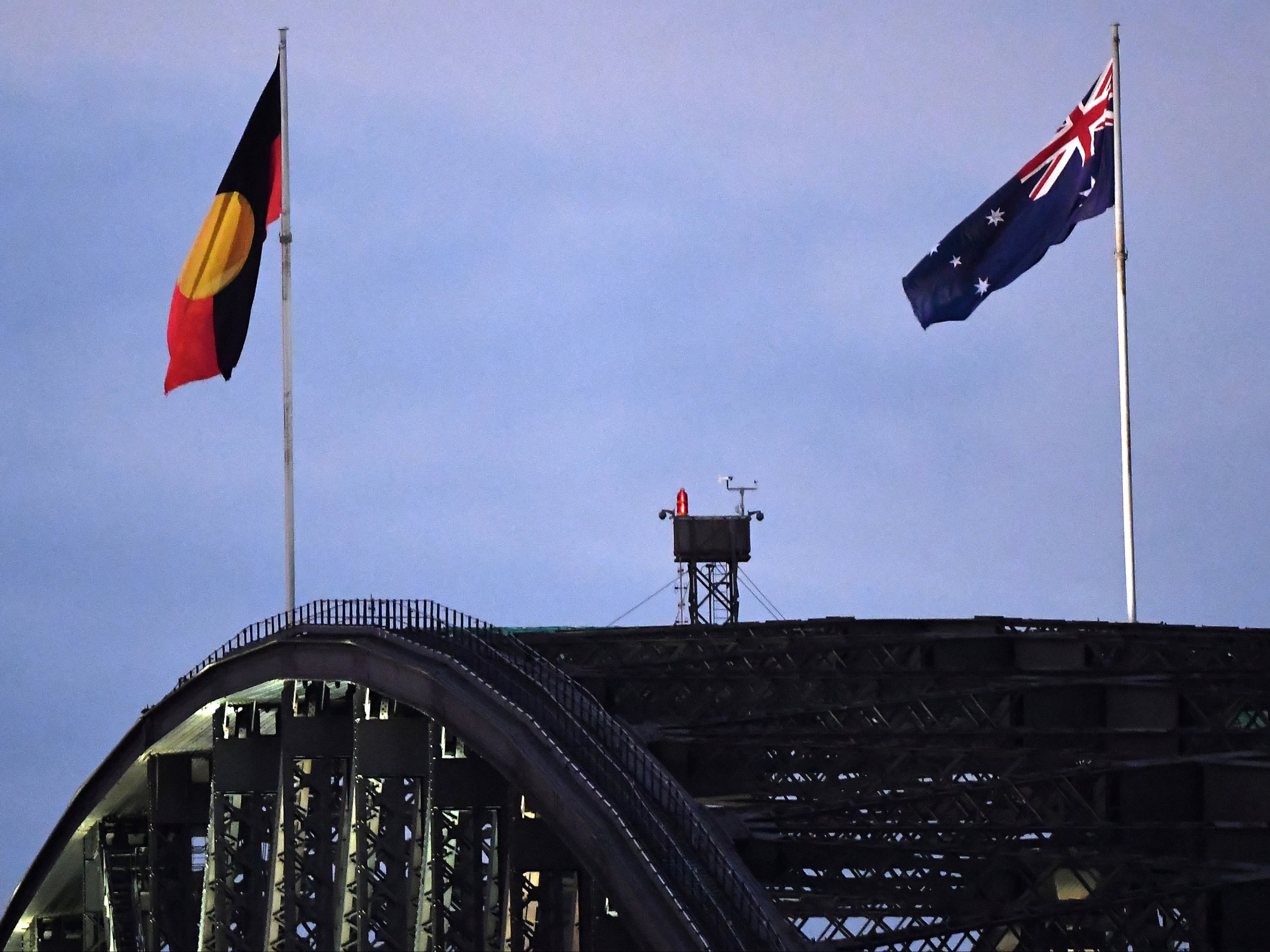 Australia’s black, red and yellow Aboriginal flag (left) flies beside Australia’s national flag over the Harbour Bridge in Sydney on 11 July in a symbolic victory for indigenous communities after a years-long fight
