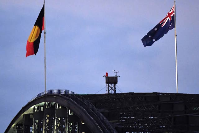 <p>Australia’s black, red and yellow Aboriginal flag (left) flies beside Australia’s national flag over the Harbour Bridge in Sydney on 11 July in a symbolic victory for indigenous communities after a years-long fight </p>