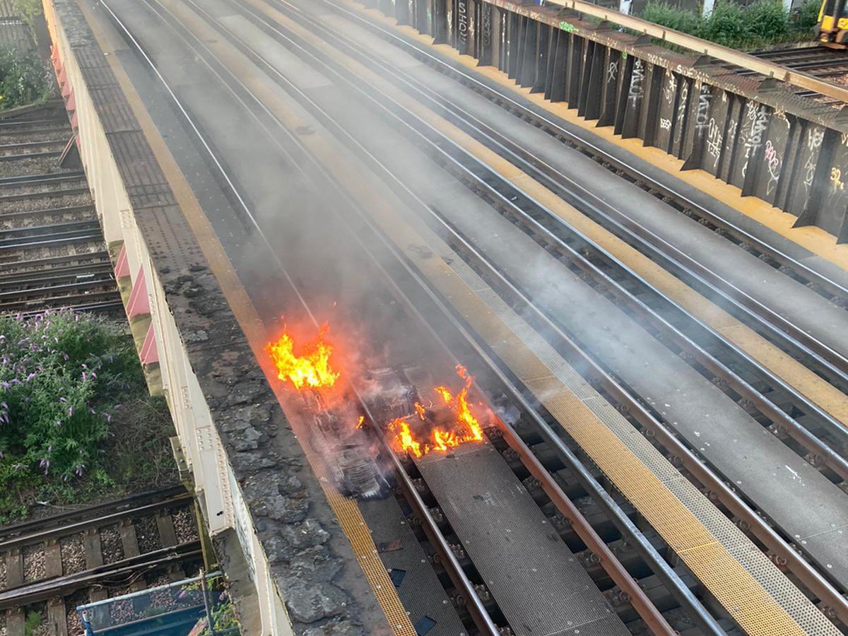 UK heatwave: Train tracks catch fire ‘from stray spark’ in 30C as services slowed to avoid buckling