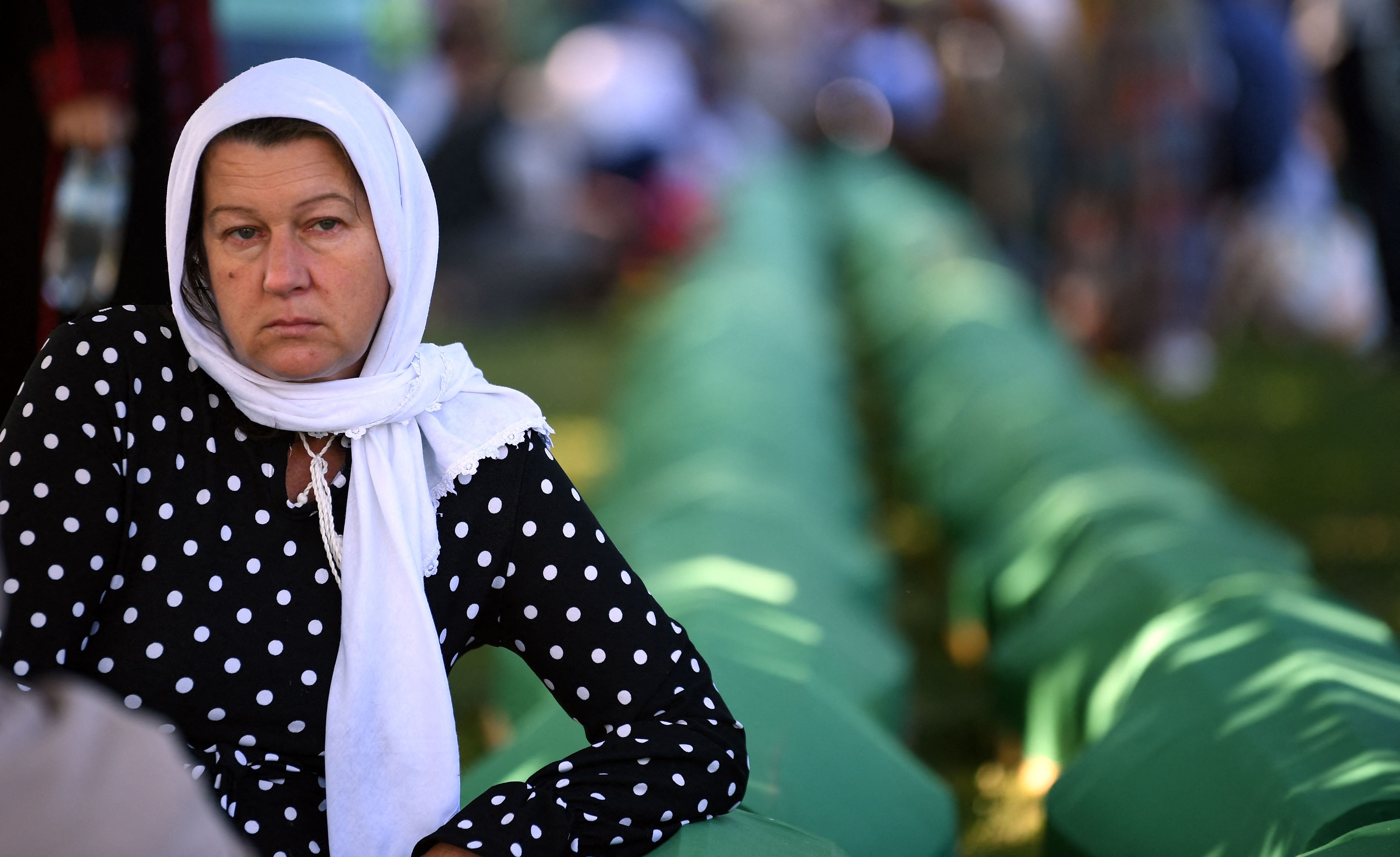 A Bosnian Muslim woman, a survivor of the 1995 Srebrenica massacre, mourns near the caskets containing remains of her relatives, at the memorial cemetery in the village of Potocari, near the eastern Bosnian town of Srebrenica