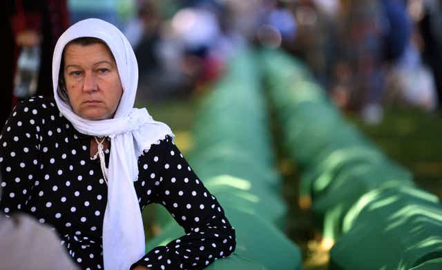 <p>A Bosnian Muslim woman, a survivor of the 1995 Srebrenica massacre, mourns near the caskets containing remains of her relatives, at the memorial cemetery in the village of Potocari, near the eastern Bosnian town of Srebrenica</p>