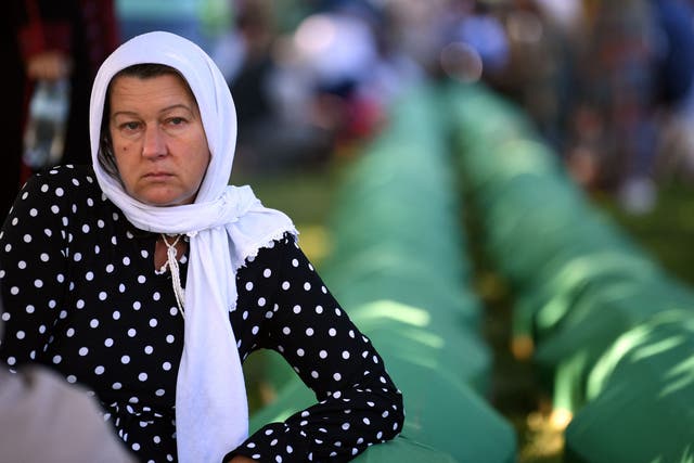<p>A Bosnian Muslim woman, a survivor of the 1995 Srebrenica massacre, mourns near the caskets containing remains of her relatives, at the memorial cemetery in the village of Potocari, near the eastern Bosnian town of Srebrenica</p>