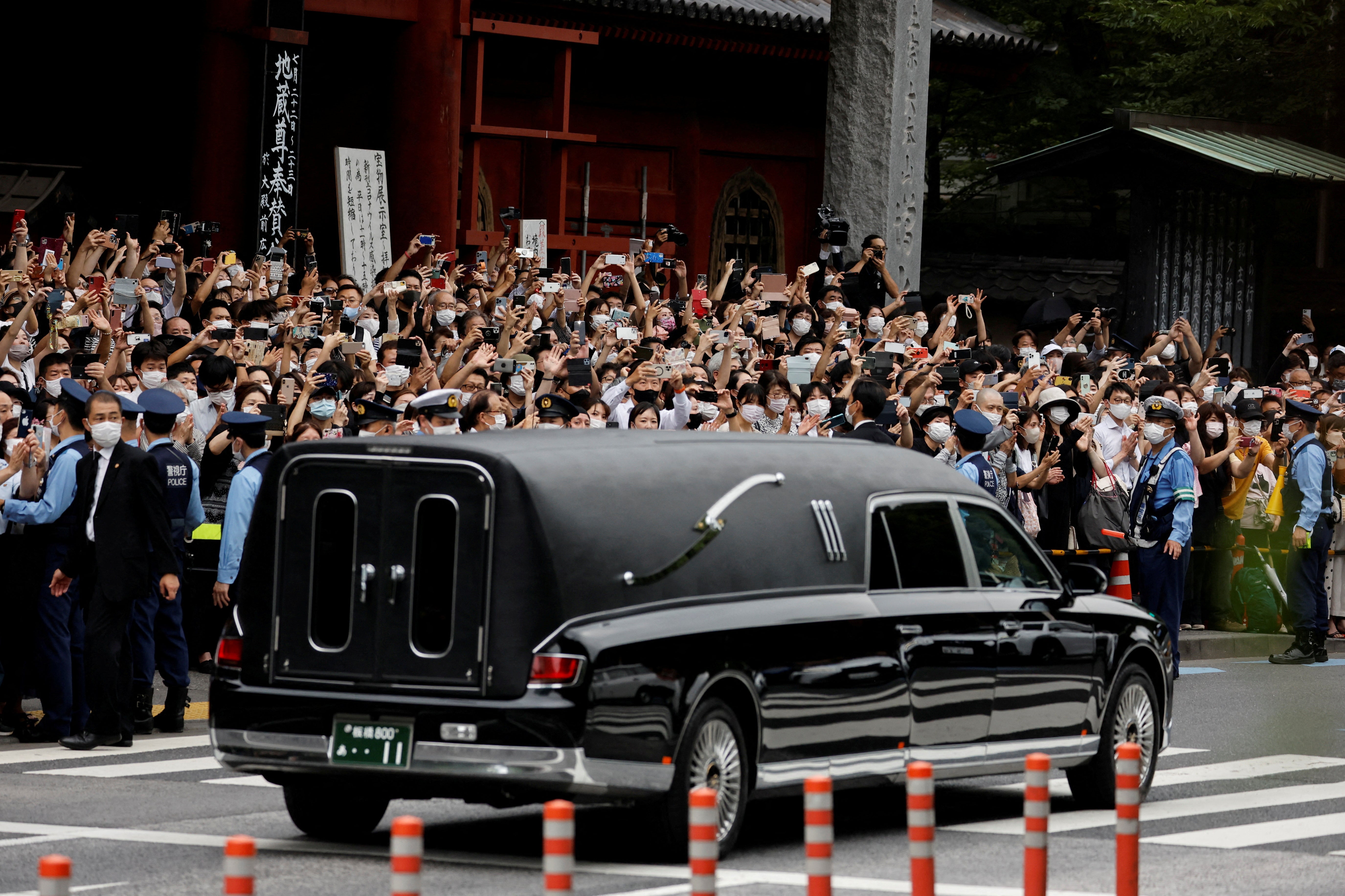 A vehicle carrying the body of the former Japanese prime minister leaves the Zojoji temple after his funeral
