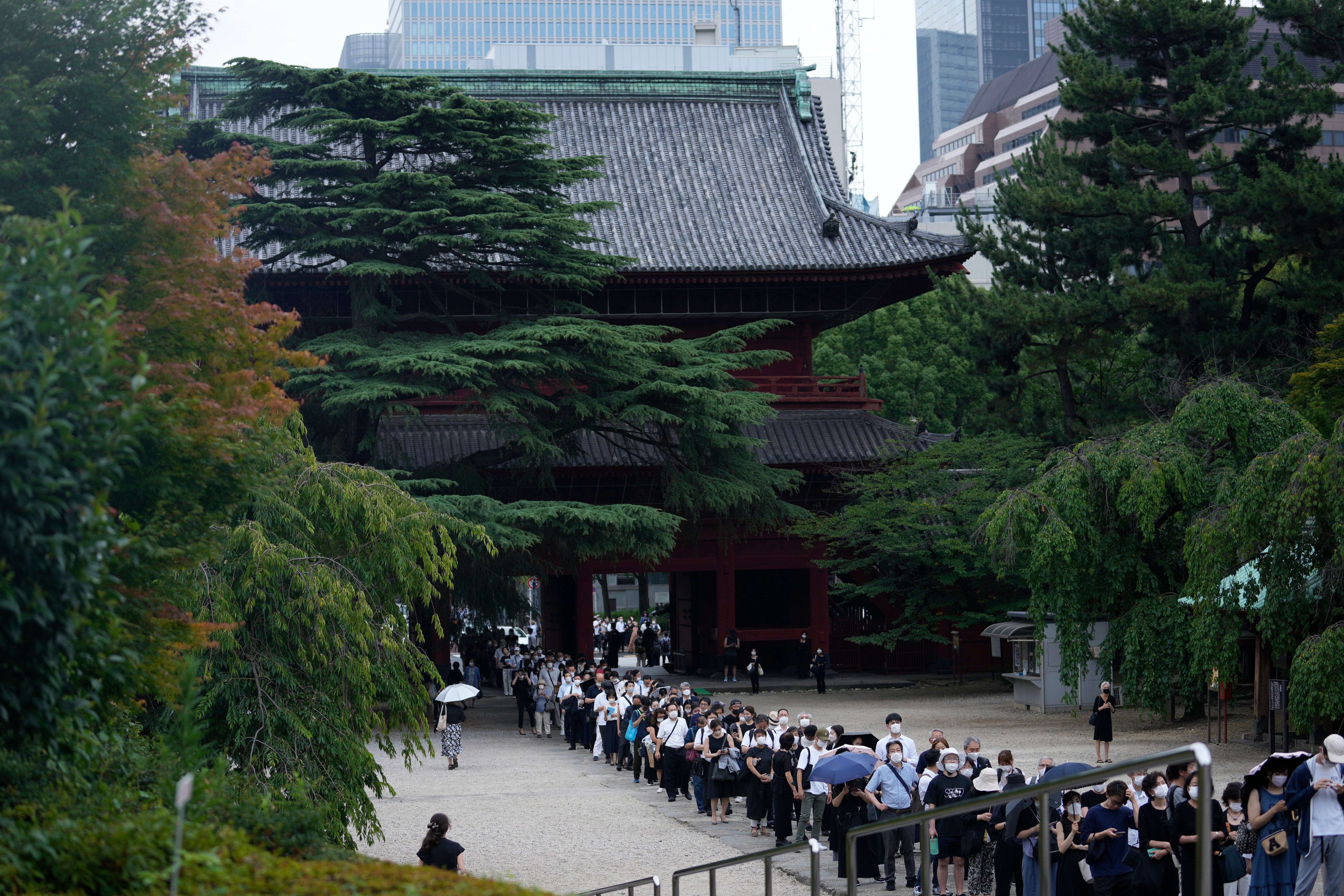 People wait in line to pay their respects to the former Japanese prime minister prior to his funeral
