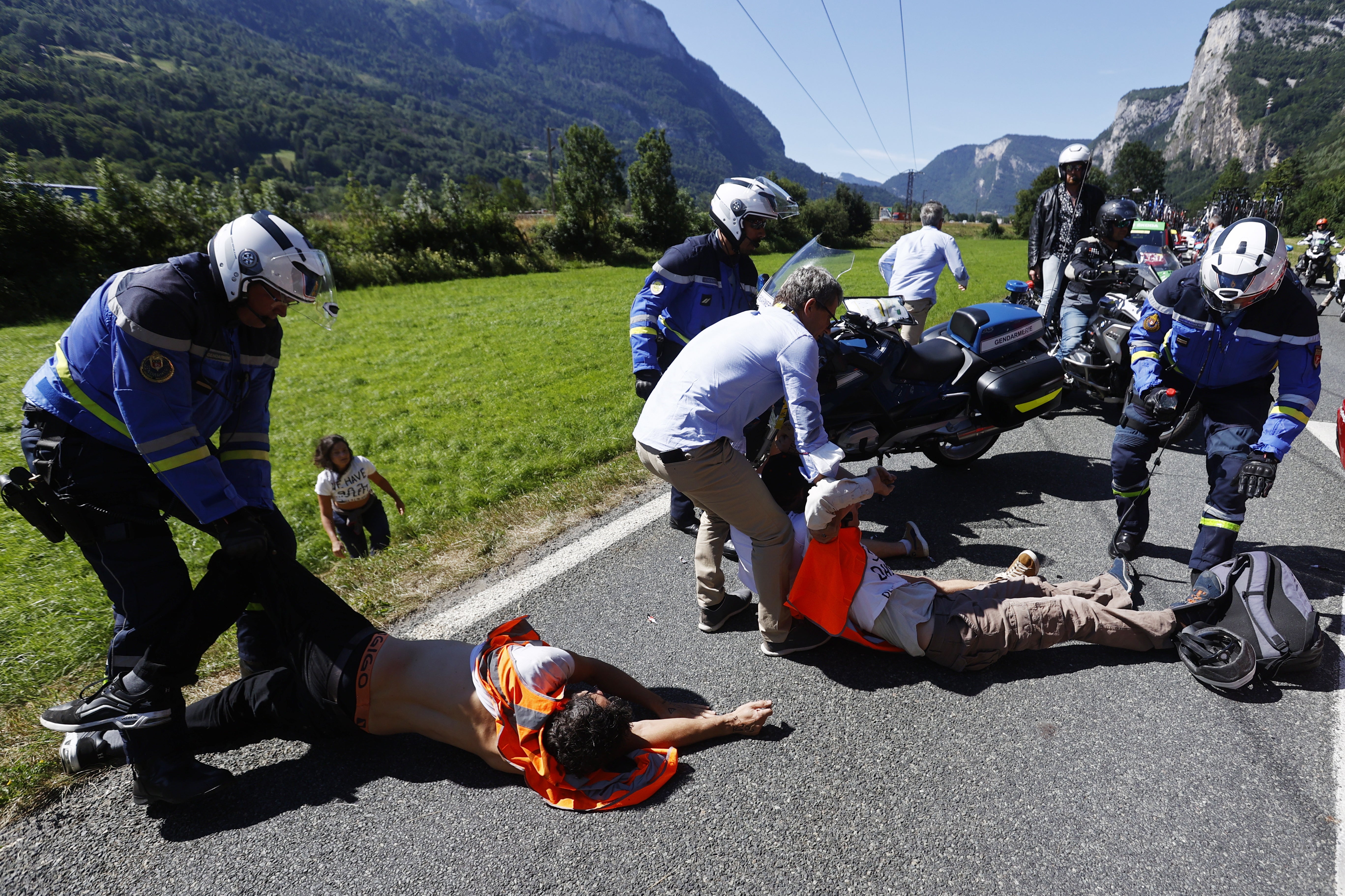 Police remove protesters from the road during the 10th stage