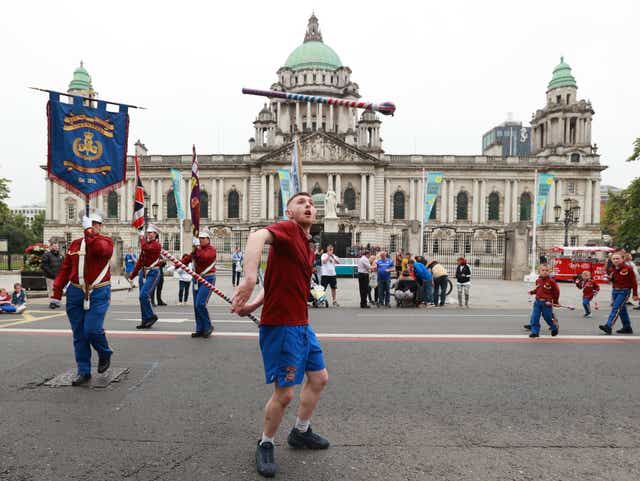 A drum major from Monkstown Young Citizen Volunteers throws a baton in the air in front of Belfast City Hall during the return leg of the Twelfth of July parade in Belfast, as part of the traditional Twelfth commemorations marking the anniversary of the Protestant King William’s victory over the Catholic King James at the Battle of the Boyne in 1690 (Liam McBurney/PA)