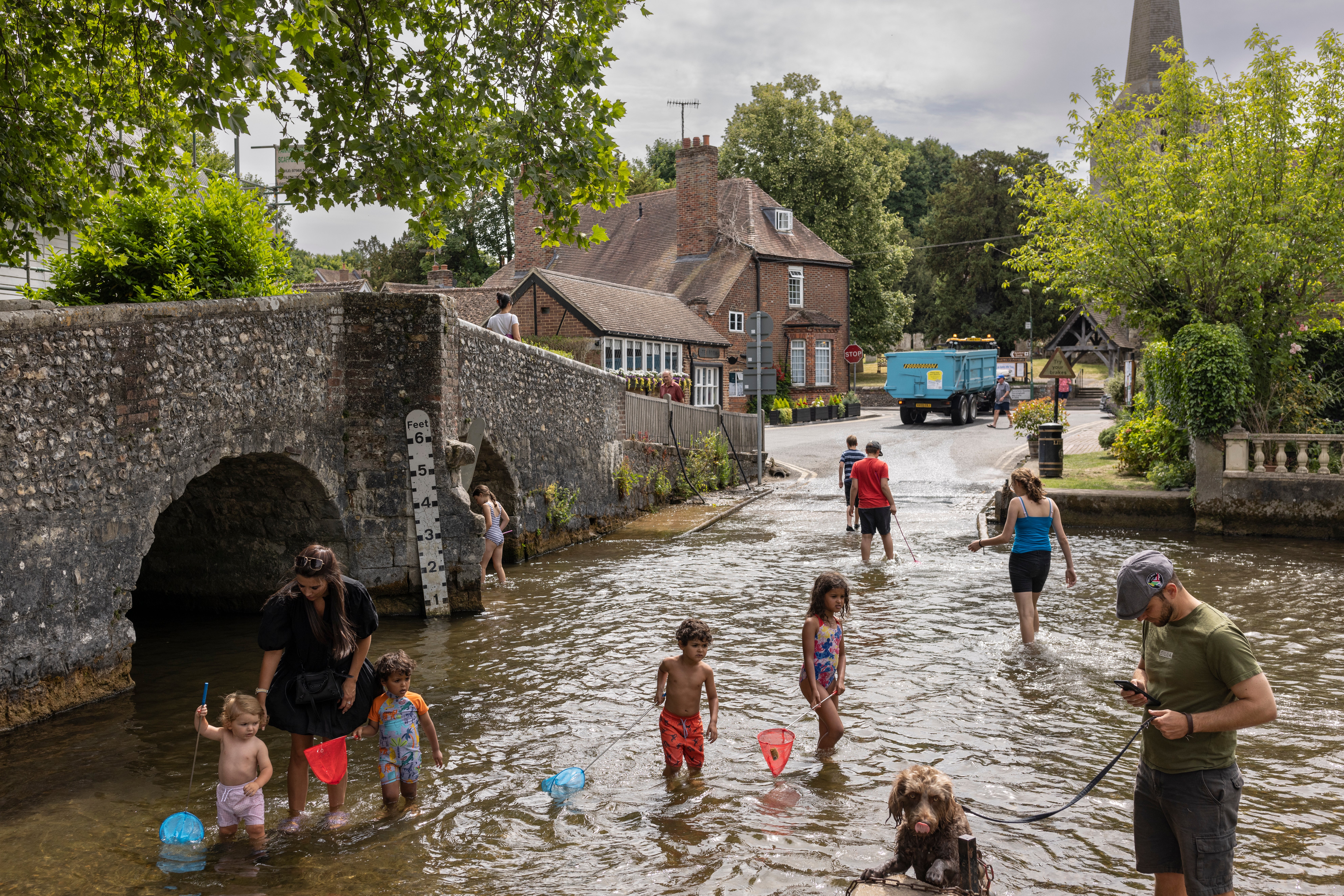 Families cool off in the River Darent in Eynsford on Tuesday