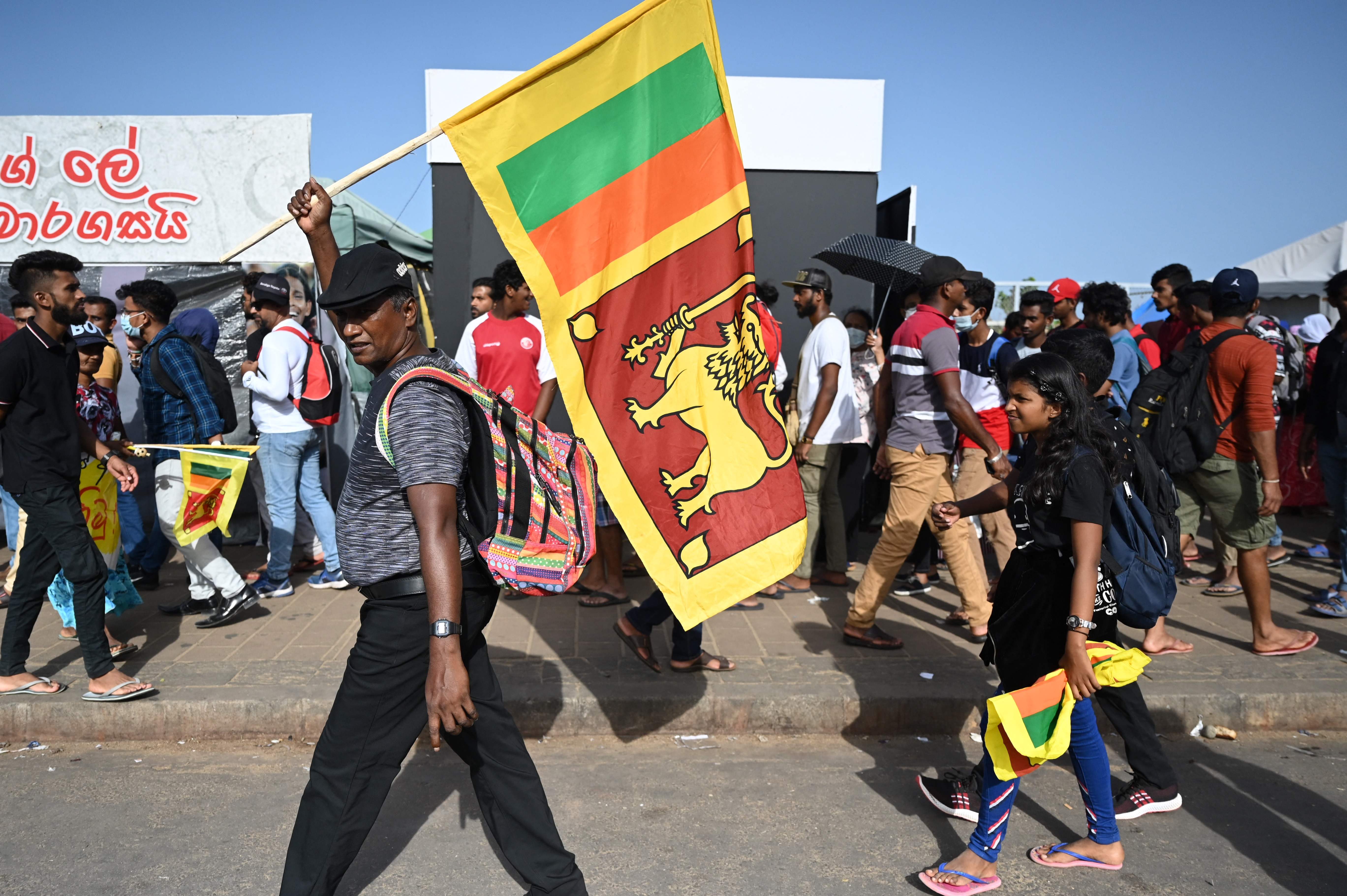 A man waves Sri Lanka’s national flag outside presidential secretariat in Colombo