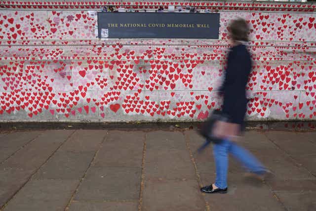 People walk past the Covid memorial wall in central London (Jonathan Brady/PA)