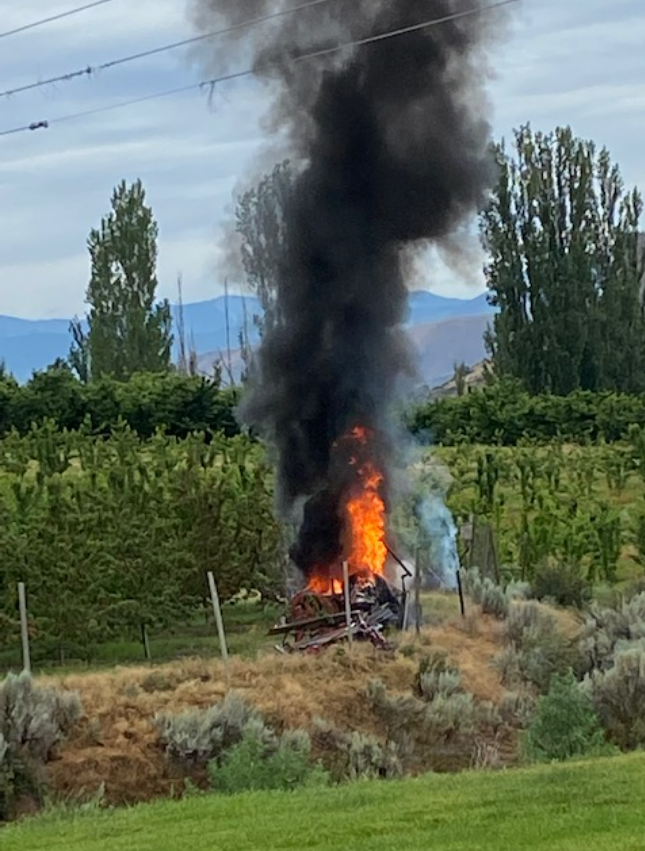 The flames from a crash between a helicopter and a tractor in Washington State can be seen stretching high into the air and nearly reaching the power lines