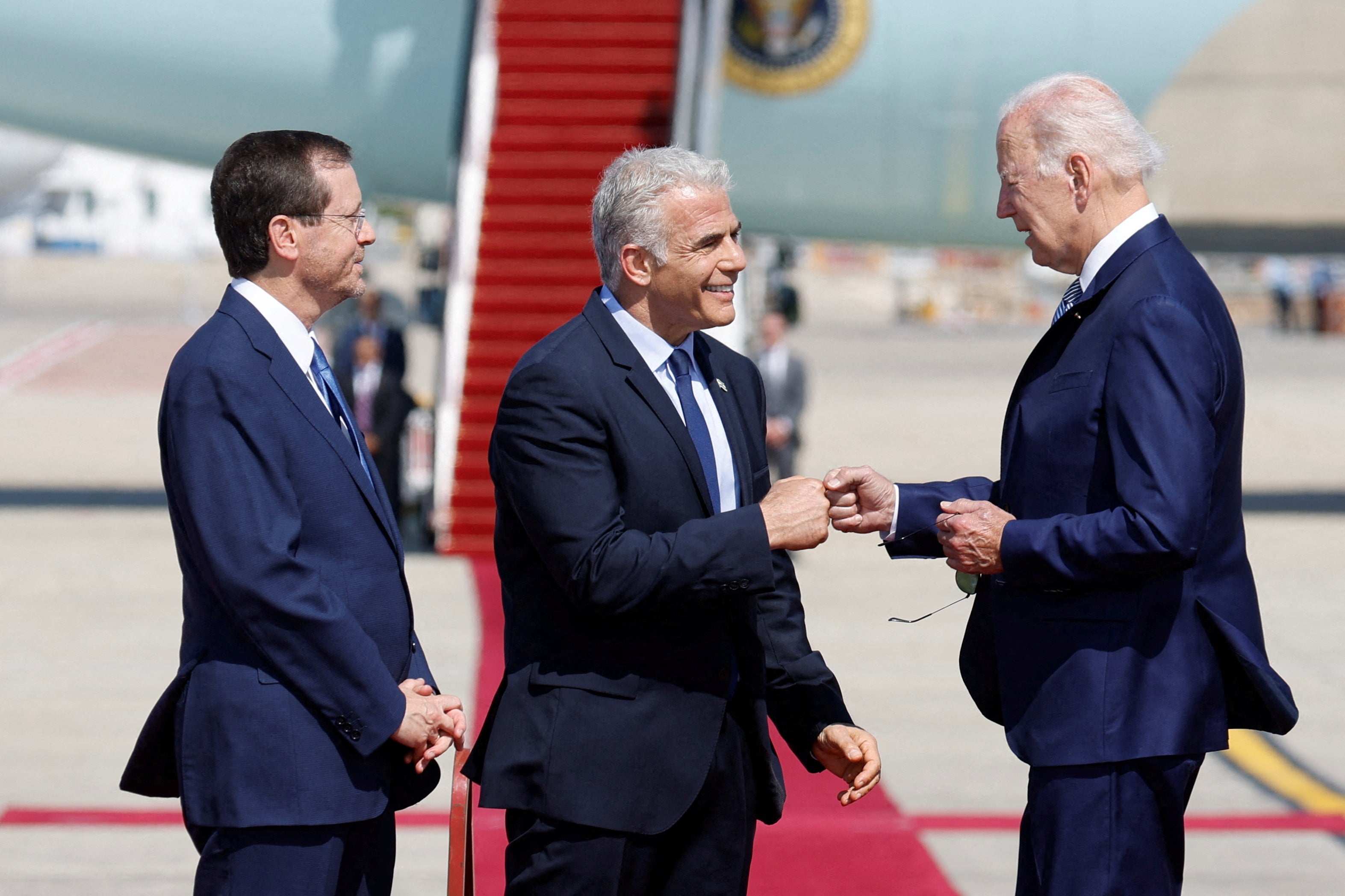 Joe Biden is greeted by the Israeli president Isaac Herzog, left, and Prime Minister Yair Lapid , on his arrival