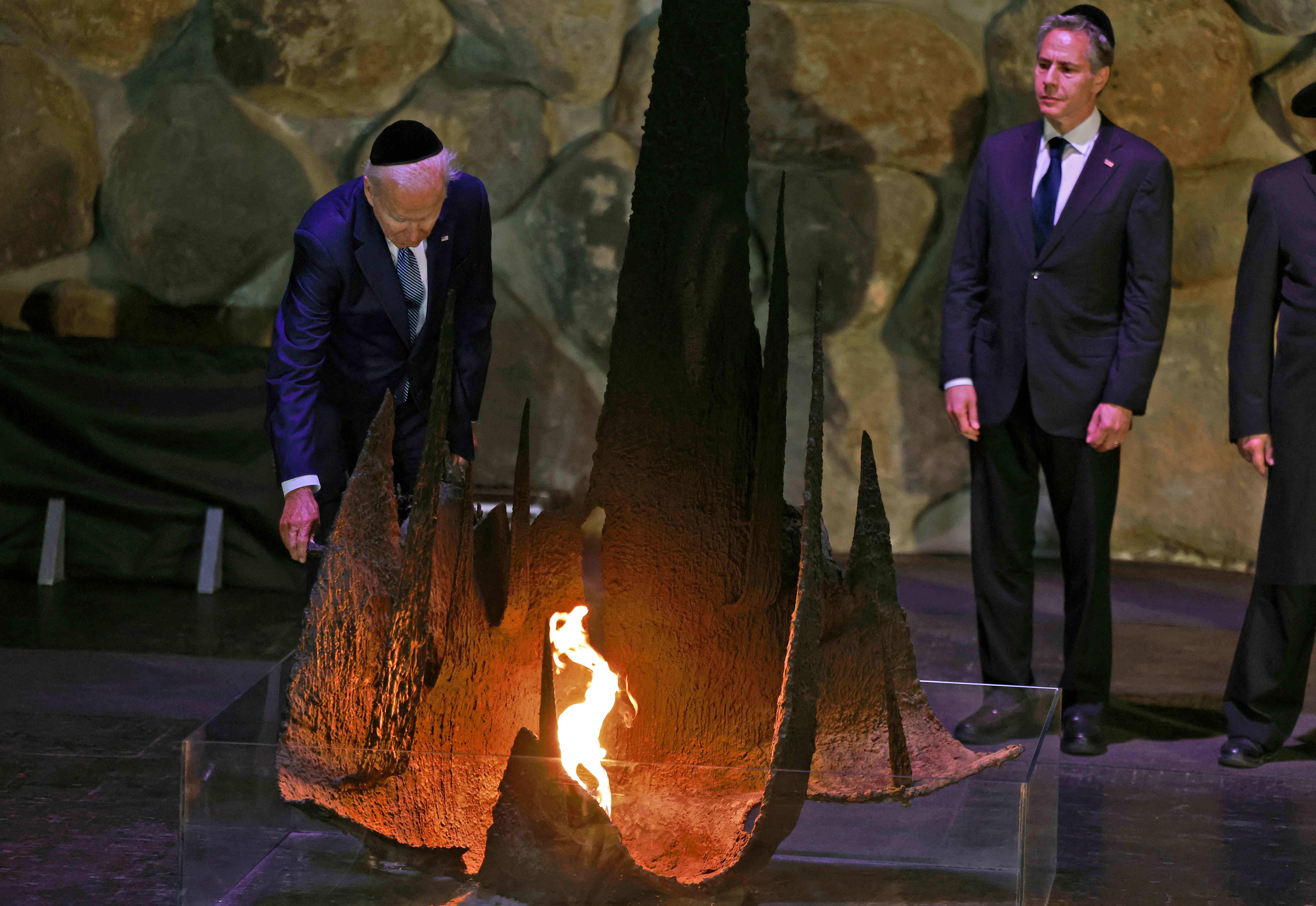 President Joe Biden rekindles the Eternal Flame at the Hall of Remembrance at the Yad Vashem Holocaust Memorial museum as Secretary of State Antony Blinken looks on