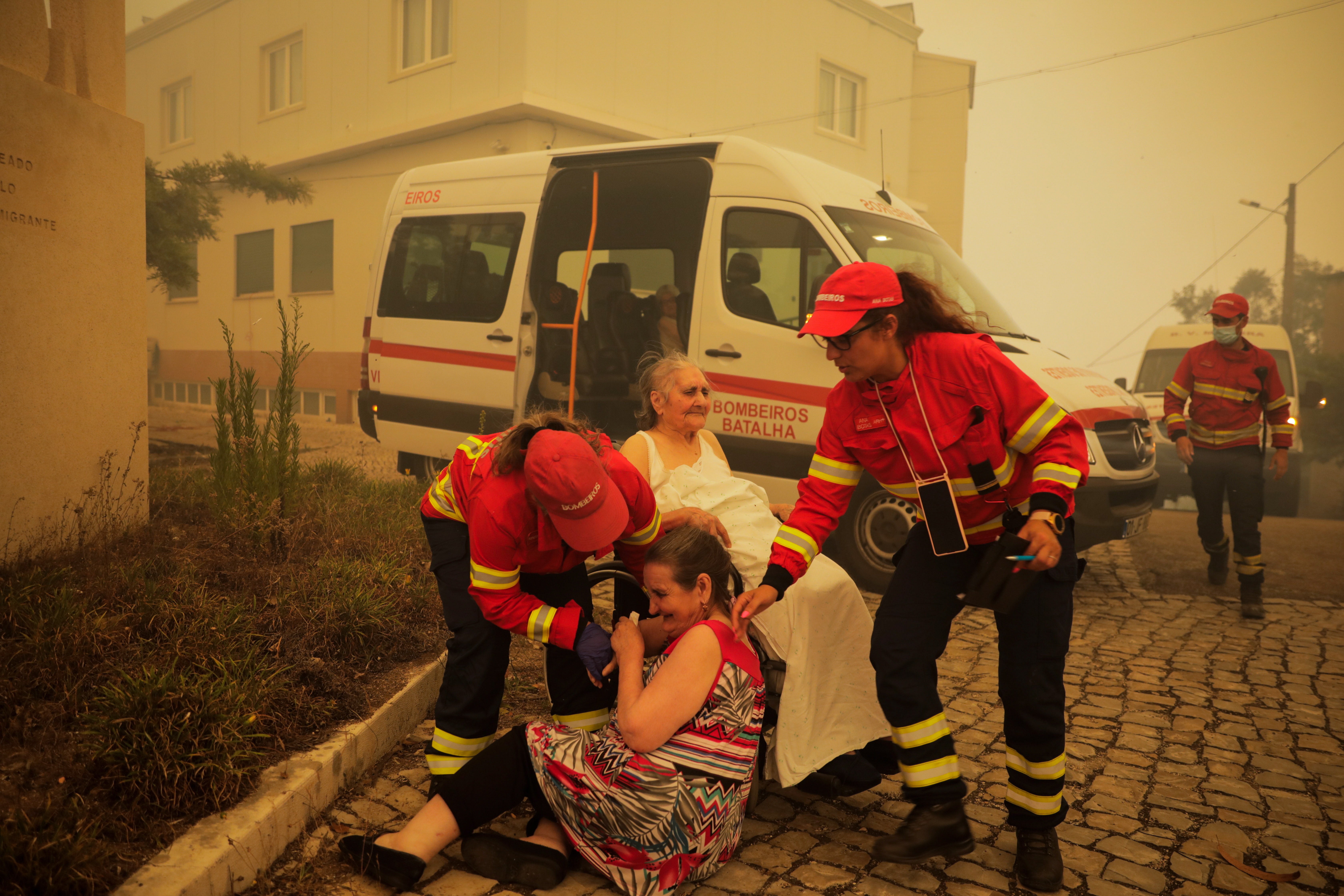 Firefighters evacuate elderly people from a nursing home in the village of Memoria, Portugal