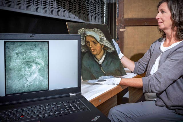 Senior paintings conservator Lesley Stevenson views Head of a Peasant Woman alongside an x-ray image of the hidden Van Gogh self-portrait (Neil Hanna/National Galleries of Scotland)
