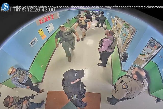<p>Video from the Uvalde, Texas shooting showed armed police officers waiting outside classrooms for over an hour while the shooter continued his massacre </p>