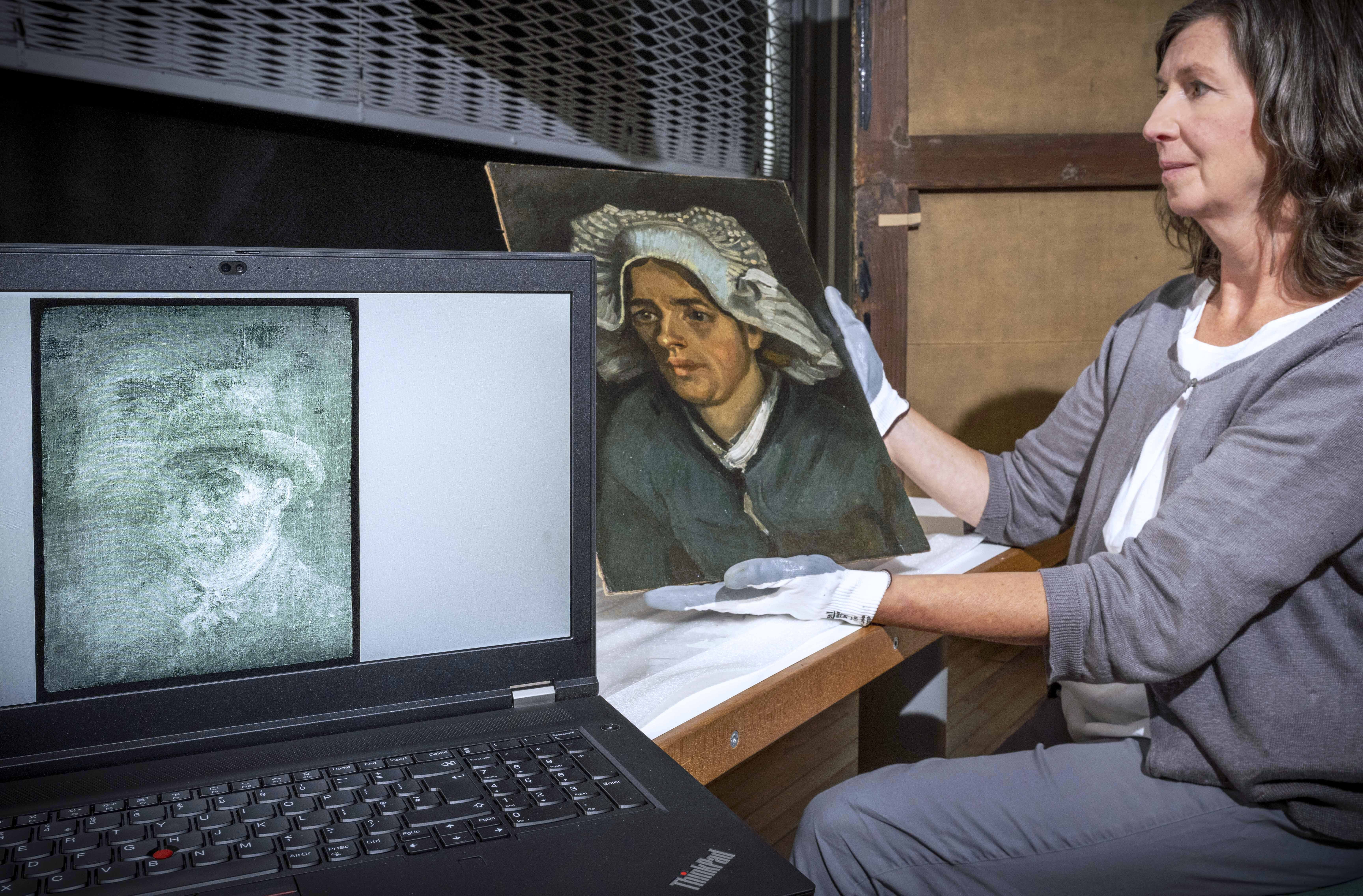 Senior conservator Lesley Stevenson views Head Of A Peasant Woman alongside an X-ray image of the hidden Vincent Van Gogh self-portrait (Neil Hannah/National Galleries of Scotland/PA)