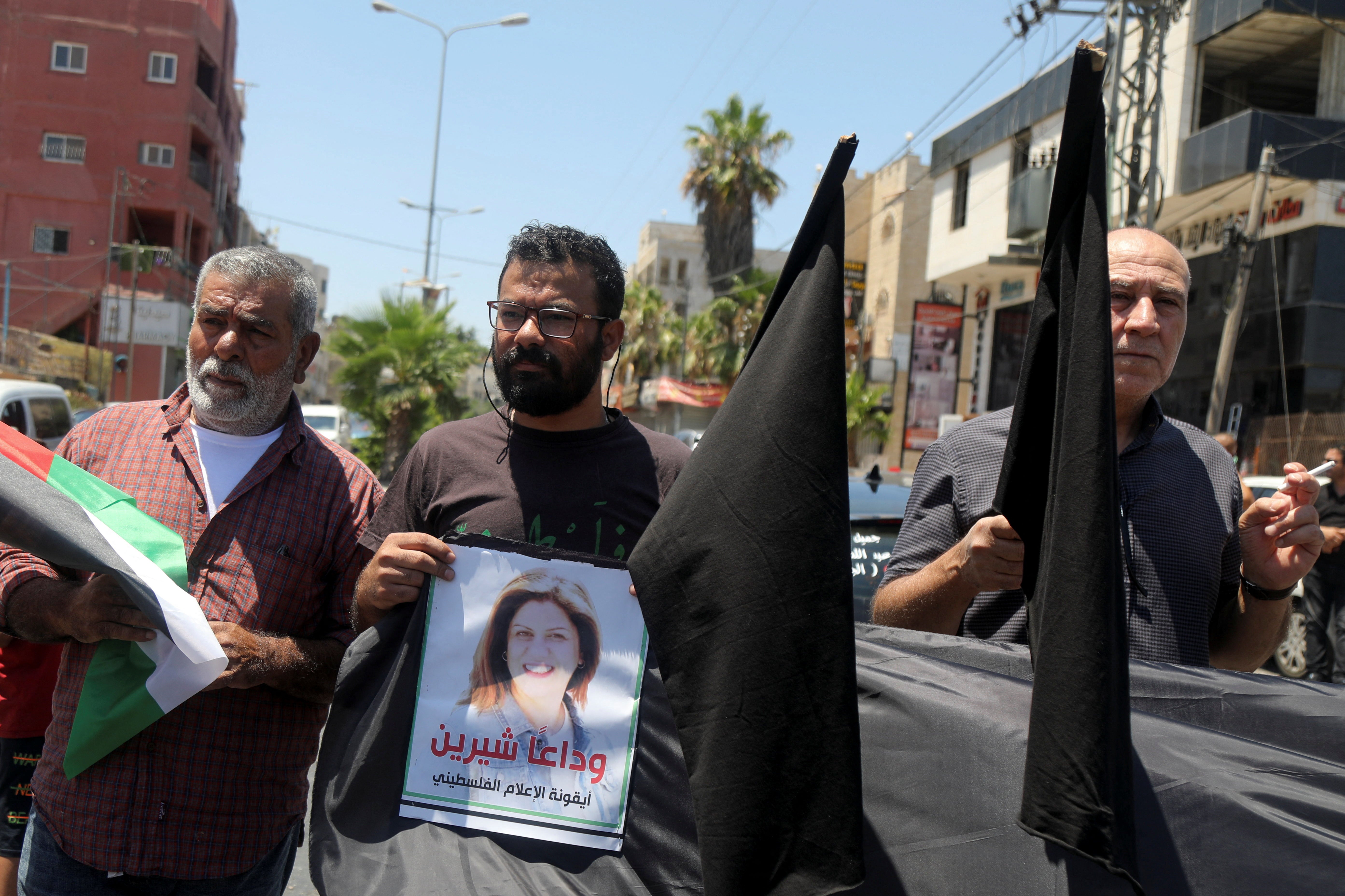 A protestor holds up a picture of slain Palestinian-American journalist Shireen Abu Akleh, as Palestinians demonstrate against the visit of US president Joe Biden to Bethlehem