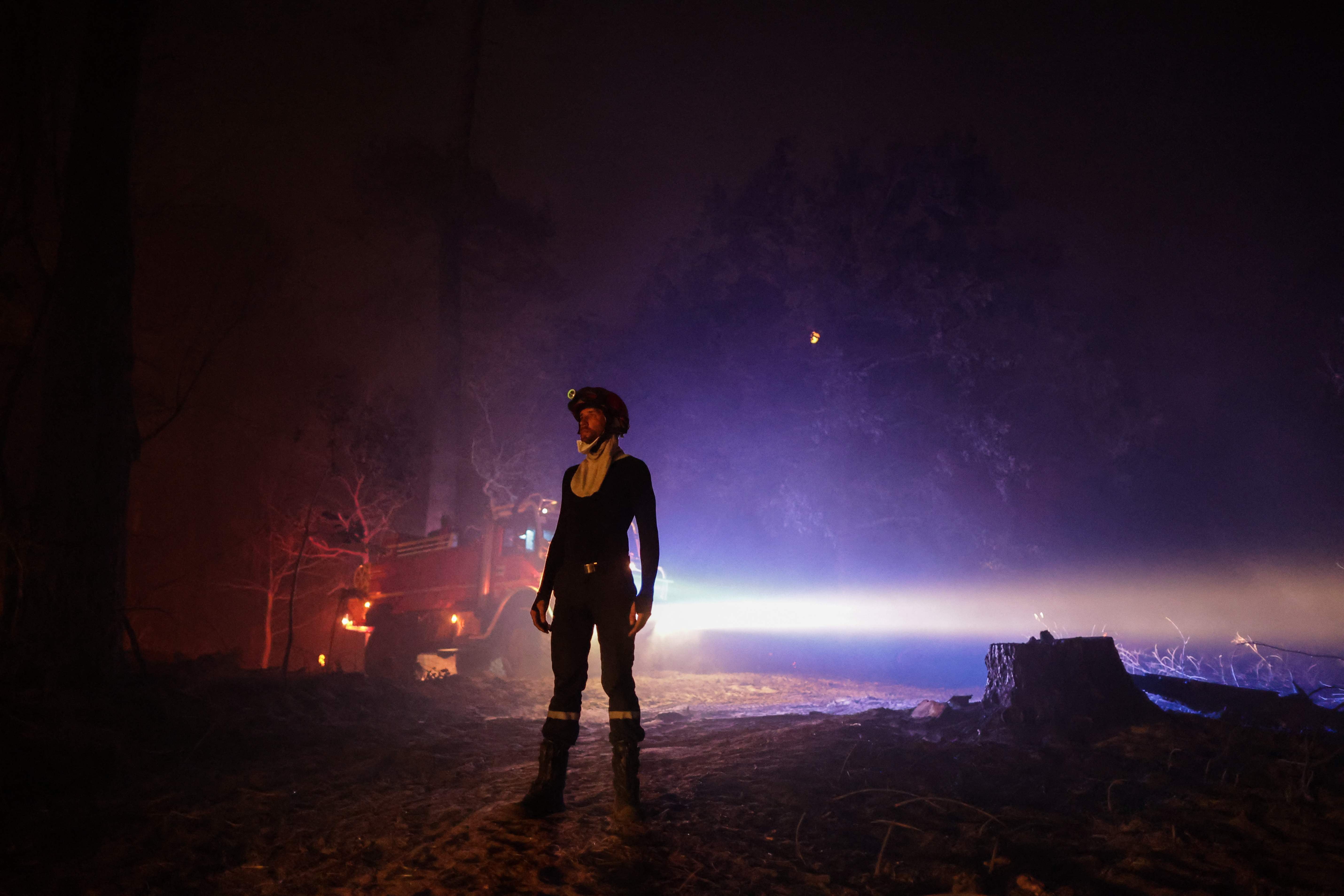 A firefighter stands as a wildfire burns near La Teste-de-Buch, southwestern France