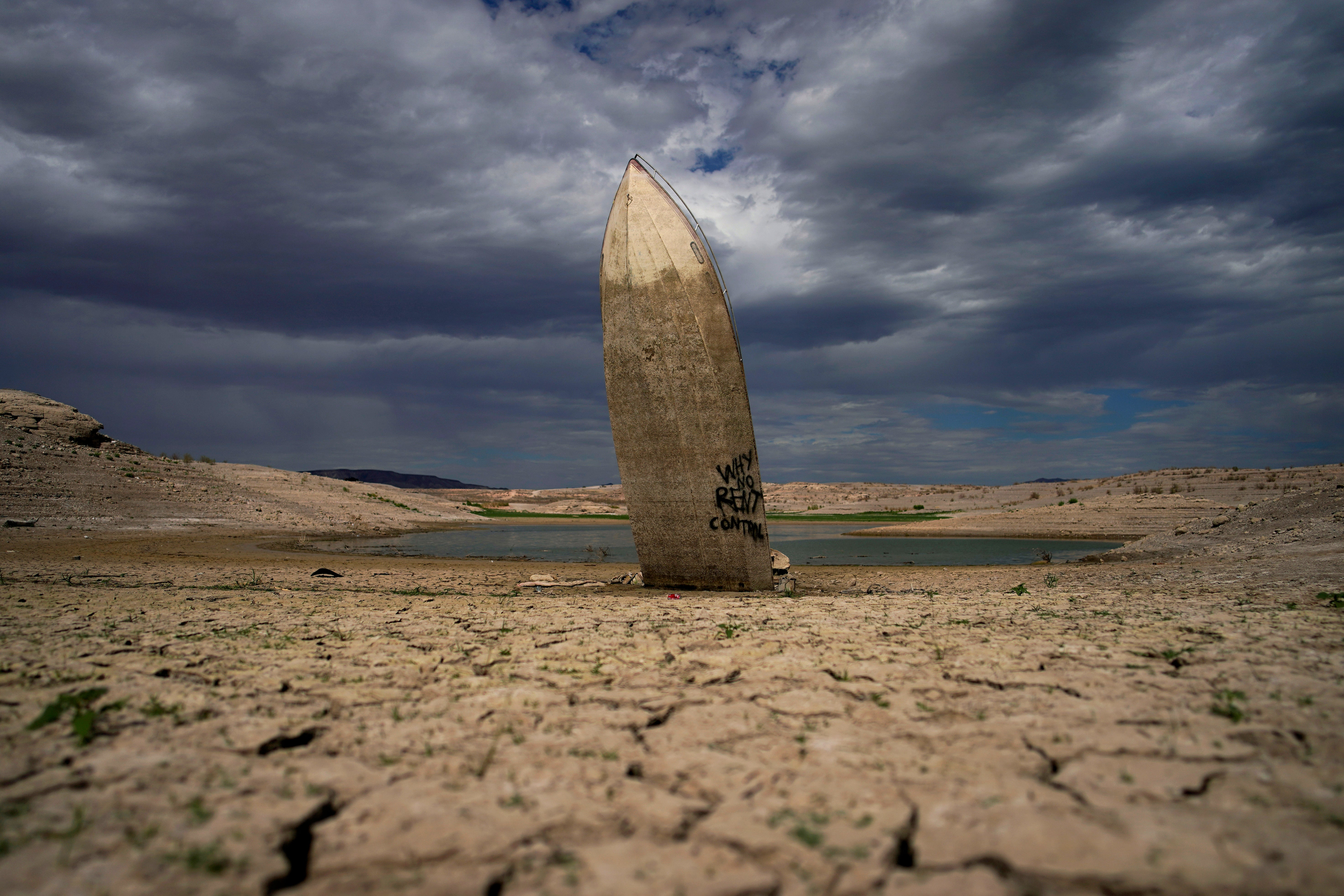 A formerly sunken boat stands upright into the air along the shoreline of Lake Mead on Wednesday, June 22, 2022, near Boulder City, Nevada