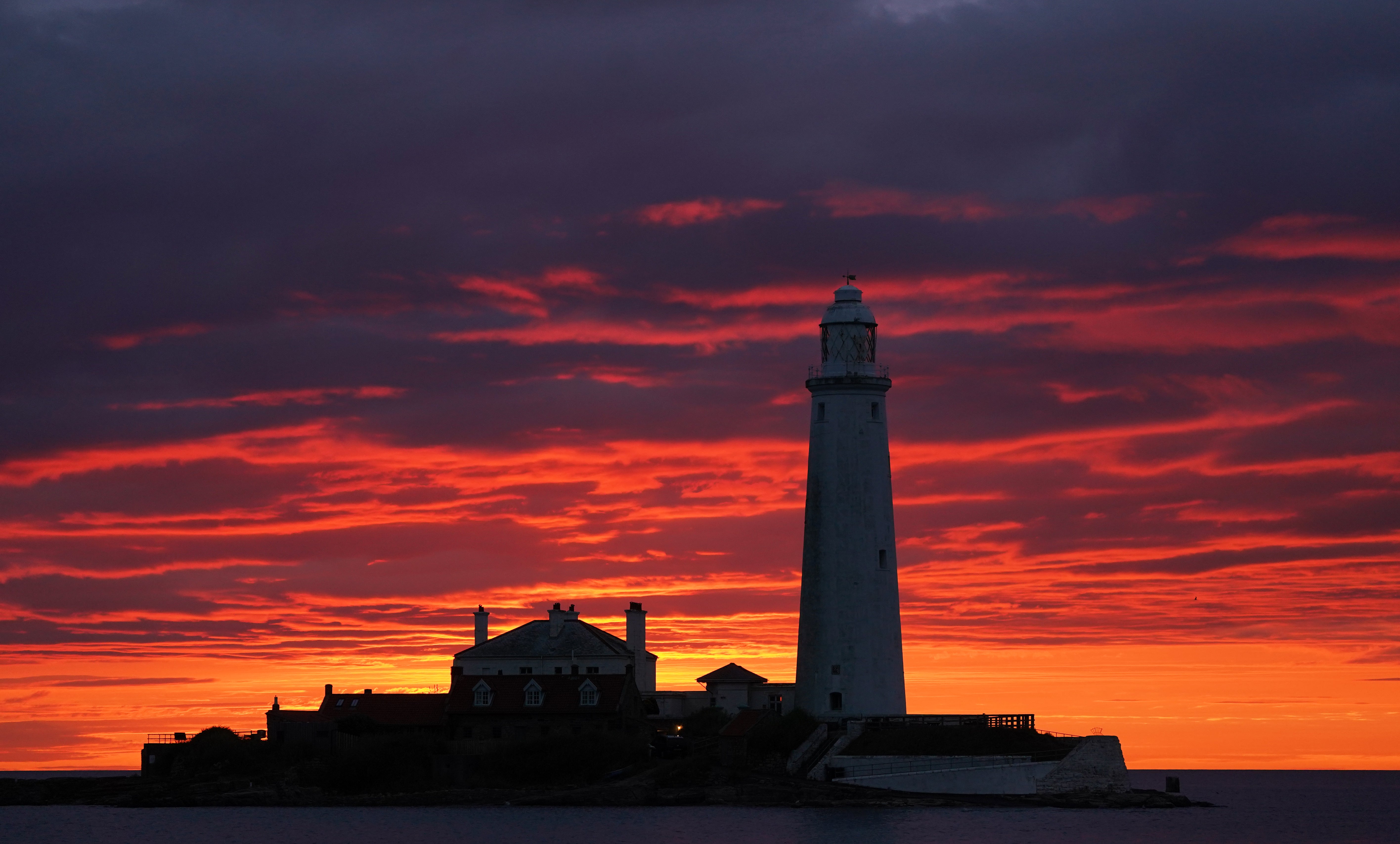 A fire coloured sky above St Mary’s Lighthouse in Whitley Bay (PA)