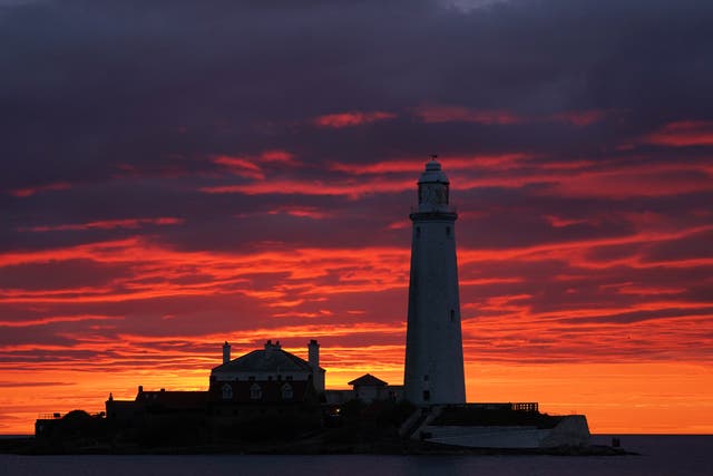 A fire coloured sky above St Mary’s Lighthouse in Whitley Bay (PA)