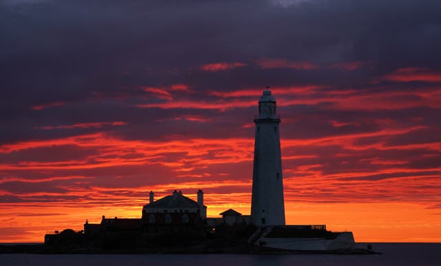 A fire coloured sky above St Mary’s Lighthouse in Whitley Bay (PA)