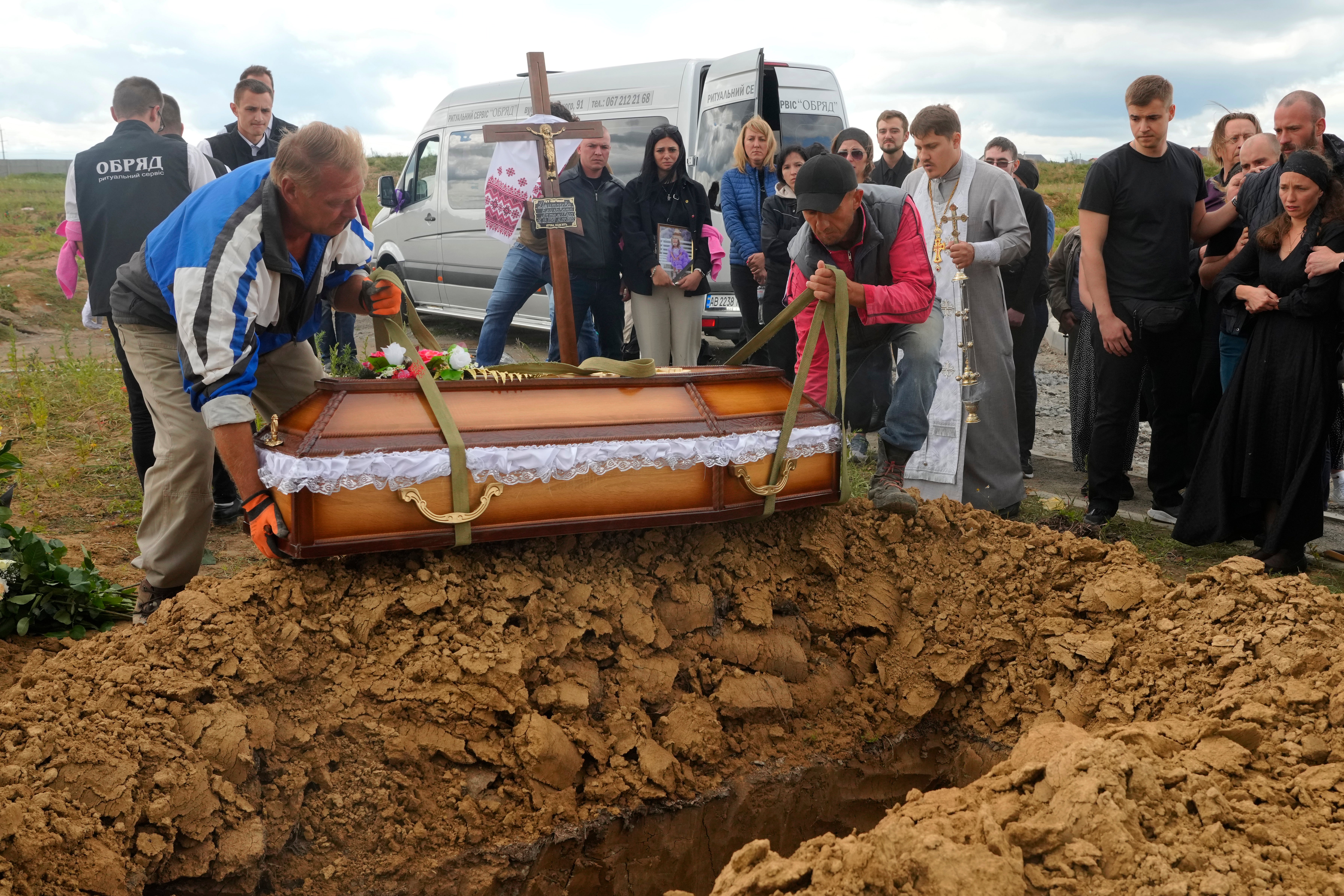 Men lower the coffin of Liza, four-year-old girl killed by Russian attack, during a funeral ceremony in Vinnytsia, Ukraine