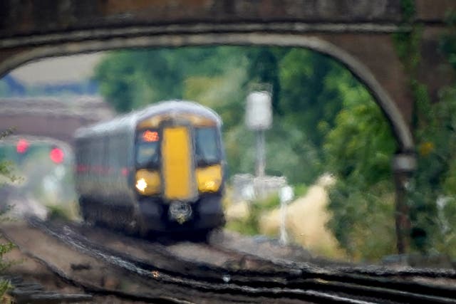 <p>A train passes through heat haze on a railway line near Ashford in Kent (Gareth Fuller/PA)</p>