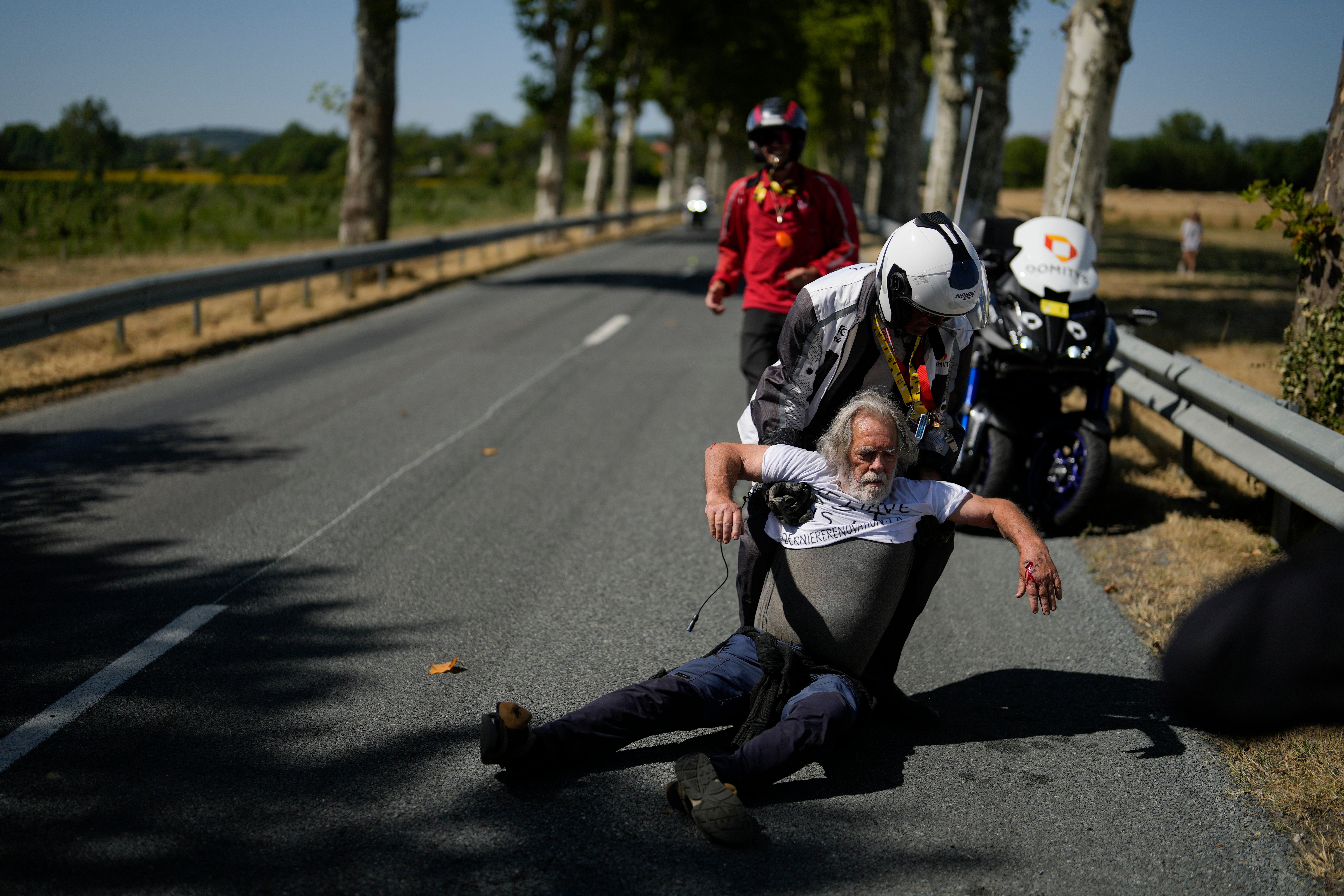 Protestors had been hauled off the road by police shortly before Steven Kruijswijk’s crash (Thibault Camus/AP)