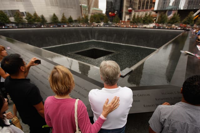 <p>Family members of 9/11 victims stand at the edge of one of the memorial pools in New York City on the attack’s 10th anniversary in 2011</p>